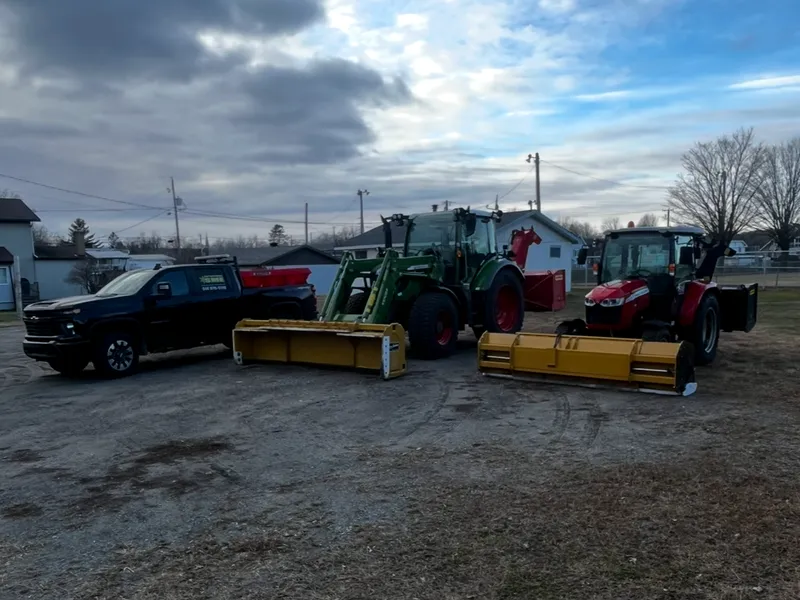 La flotte de déneigement résidentiel de l'Entreprise SME : camionnette, tracteur Fendt et tracteur Massey Ferguson avec leurs lames jaunes, en fin de journée