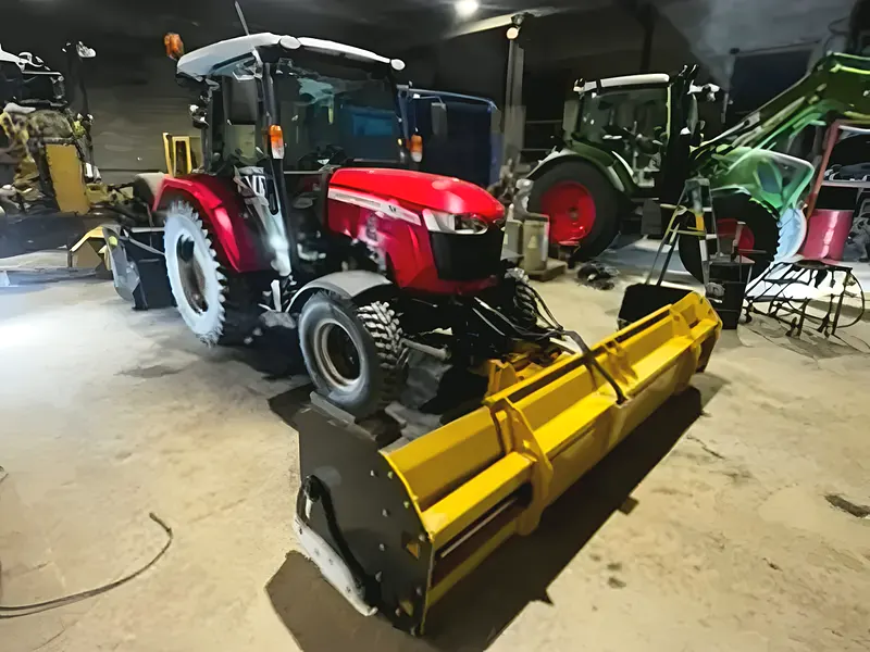 Les deux tracteurs de l'Entreprise SME dans le garage éclairé, prêts à sortir
